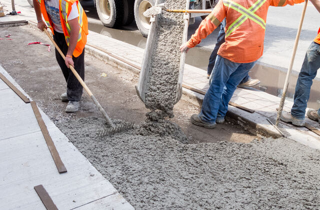Ready mix concrete being poured and finished at a construction site.